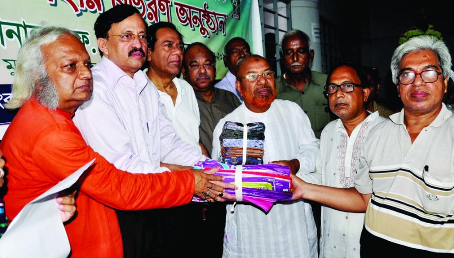 Chairman of National Freedom Fighters' Foundation Dr SM Zahangir Alam distributing Eid gifts among the insolvent freedom fighters of the city in front of the Liberation War Affairs Ministry on Wednesday.