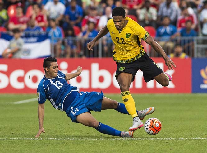 Jamaica's Gareth McCleary (right) has his feet kicked out from under him by El Salvador's Alexander Larin during a CONCACAF Gold Cup soccer match in Toronto on Tuesday.