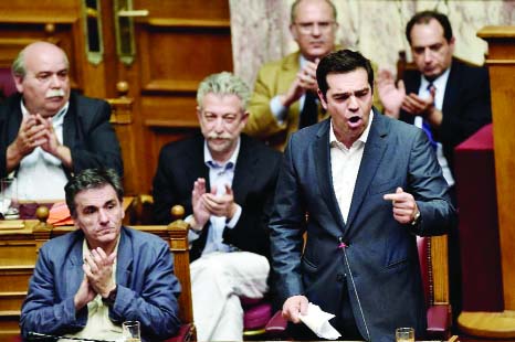 Greek Prime Minister Alexis Tsipras (R) addresses a parliamentary session in Athens on Wednesday.