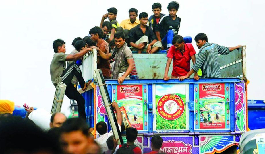 Homebound passengers going to their respective destination to celebrate Eid with their near and dear ones boarding in a truck without getting any ticket of bus. The snap was taken from the city's Amin Bazar area on Thursday.