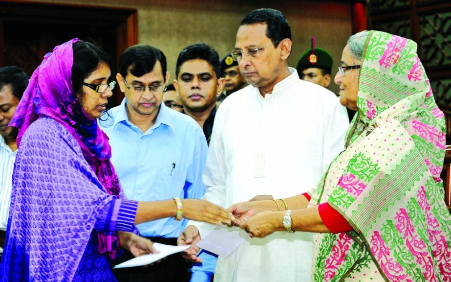 Prime Minister Sheikh Hasina distributing cheques of grant-in-aid among the insolvent journalists and also the families of journalists who were injured and died in accidents at her office on Thursday. BSS photo