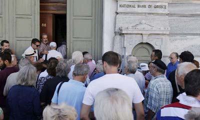 People wait to enter a National Bank branch in Athens, Greece on Monday..