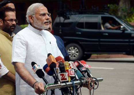 Narendra Modi talks with media on his arrival for the monsoon session at Parliament in New Delhi on Tuesday..