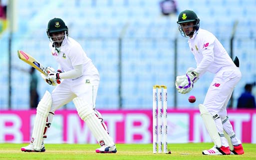 Bangladesh cricketer Shakib Al Hasan (L) plays a shot as South Africa's wicketkeeper Quinton de Kock (R) looks on during the third day of the first cricket Test match between Bangladesh and South Africa at Zahur Ahmed Chowdhury Stadium in Chittagong on T