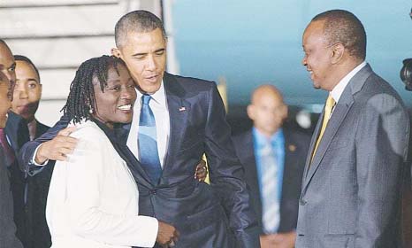Kenyan president Uhuru Kenyatta (right) watches as US President Barack Obama hugs his half-sister Auma Obama after he arrived at the Jomo Kenyatta International Airport in Nairobi, Kenya on Friday.