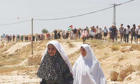 Two elderly Palestinian women stand as Israel, foreign and Palestinian activists take part in a march to protest against the demolitions of susy, a West Bank village on Friday..