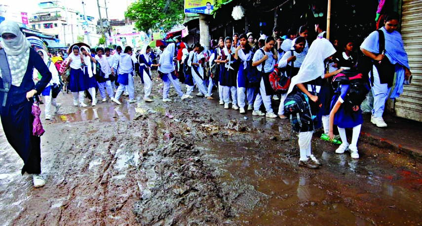 School children struggle through the muddy Manda-Mugda road due to absence of proper drainage system. The situation remains the same for long but the authority concerned remains indifferent to mitigate the plights of road users. The snap was taken from th