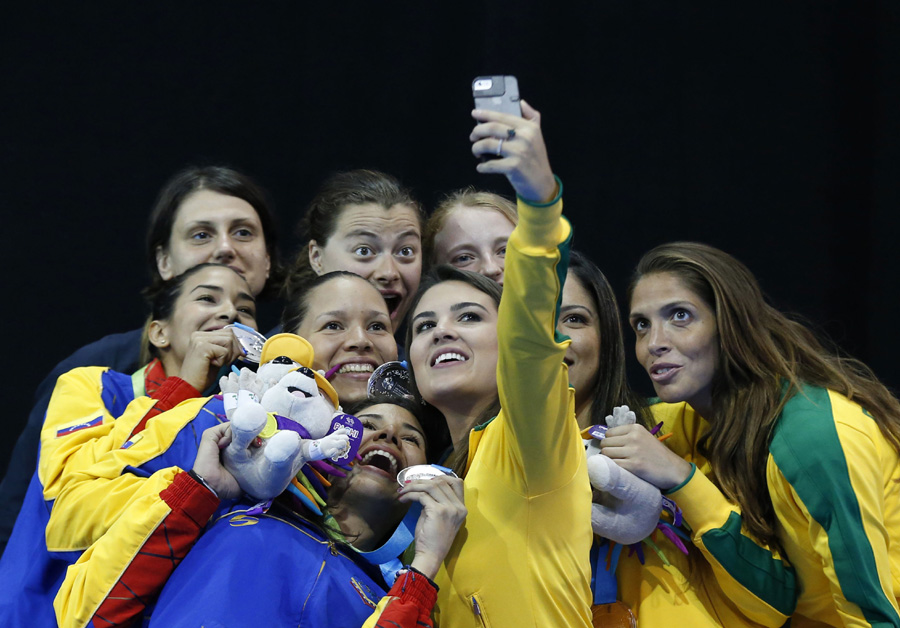 Medalists in the women's epee team fencing competition pose together for a selfie on the medals podium at the Pan Am Games in Toronto on Friday. Included are U.S. gold medalists Katharine Holmes, Katarzyna Trzopek, and Anna Catherine Van Brummen; Venezue