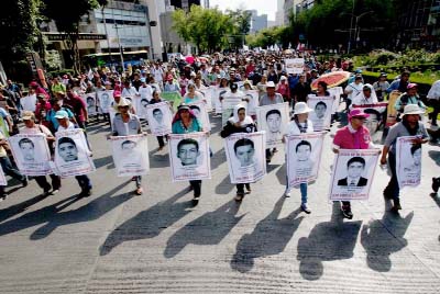 Relatives of the 43 missing students from the Isidro Burgos rural teachers college march holding pictures of their missing loved ones during a protest in Mexico City, on Sunday.