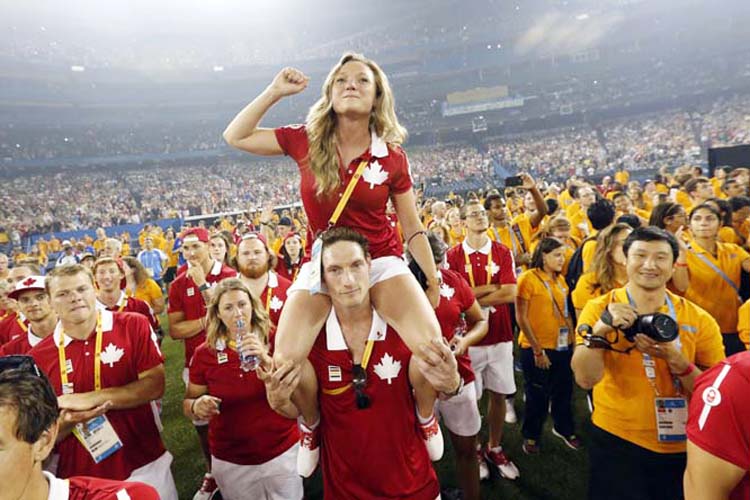 Canadian athletes Rosannagh MacLennan sits on the shoulders of Joshua Binstock as they listen to the entertainment during the closing ceremony of the Pan Am Games in Toronto on Sunday.