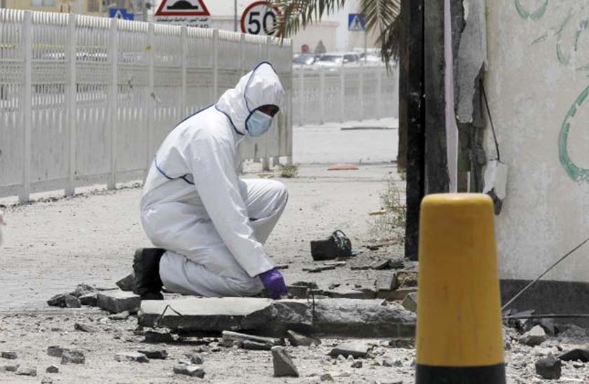 An explosives specialist police officer conducts an investigation after a bomb blast in the village of Sitra, south of Manama, Bahrain.