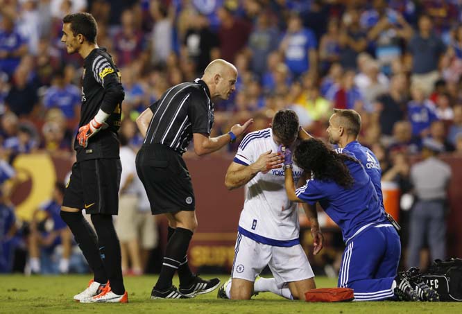 Barcelona goalkeeper Jordi Masip LÃ³pez stands left as trainers work on Chelsea's Gary Cahill's bloody nose after Cahill scored during the second half of an International Champions Cup soccer match in Washington on Tuesday. The game was decided on pen