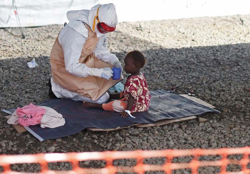 An health worker gives a drink to an Ebola patient at Kenama treatment center run by the Red Cross Society.