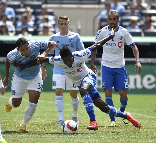 Montreal Impact defender Ambroise Oyongo (center) controls the ball against New York City FC midfielder Javier Calle (left) teammate Angelino (center) and Impact forward Andres Romero (right) look on in first half of an MLS soccer game at Yankee Stadium