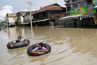 Men wade along a flooded street at Kalay township at Sagaing division, on Sunday.
