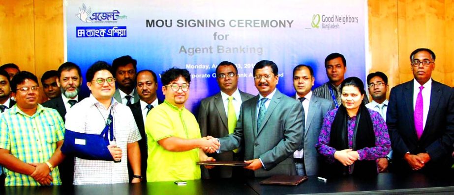 Md Mehmood Husain, Managing Director of Bank Asia Limited and Jeoung Sek Kim, Country Director of Good Neighbors Bangladesh, an international NGO, exchanging MoU documents on facilitating financial transaction support to the NGO beneficiaries through the