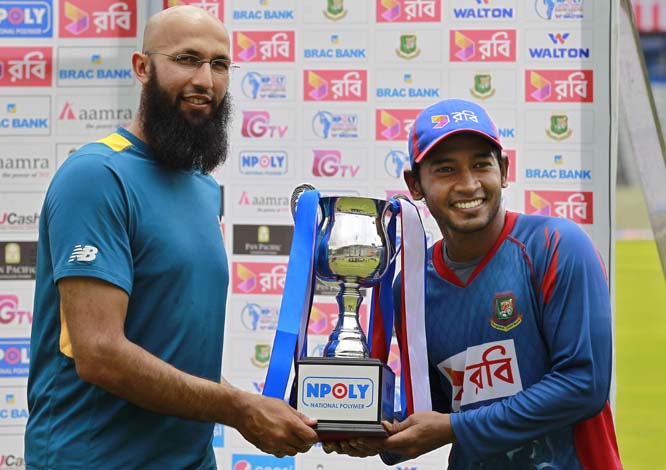 South African cricket team captain, Hashim Amla, left, and his Bangladeshi counterpart, Mushfiqur Rahim, pose with the trophy after a two test match series between the two countries ended in a draw in Dhaka on Monday.