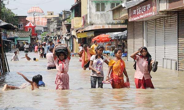 Women and children walk on a flooded sreet in Kalkata on Tuesday.