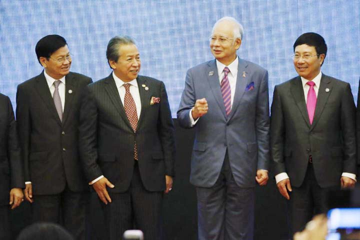 Malaysian Prime Minister Najib Razak, center right, stands with Vietnam's Foreign Minister Pham Binh Minh, right, Malaysia's Foreign Minister Anifah Aman, center left, and Laos Foreign Minister Thongloun Sisoulith during a group photo for the 48th ASEAN