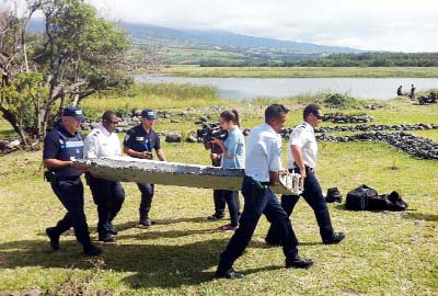 Police carry a piece of debris from an unidentified aircraft found on the French Indian Ocean island of La Reunion.