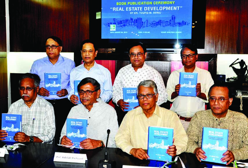 Former UGC Chairman Prof Nazrul Islam and Bishwa Sahitya Kendra President Prof Abdullah Abu Sayeed along with other distinguished persons hold the copies of a book titled 'Real Estate Development' written by Managing Director of Sheltech Dr Taufiq M Ser