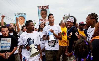 Demonstrators protest during a march on Saturday at the Ferguson Police Department marking the first anniversary of the police shooting of unarmed black teen Michael Brown.