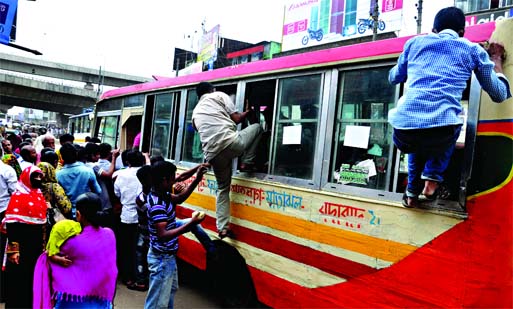 NOT AN ACROBATIC PERFORMANCE: Office-goers' desperate bid to have a space inside the bus as many buses disappeared from the city roads with the beginning of police drive against unfit vehicles. This photo was taken from Sayedabad area in the city on Mond