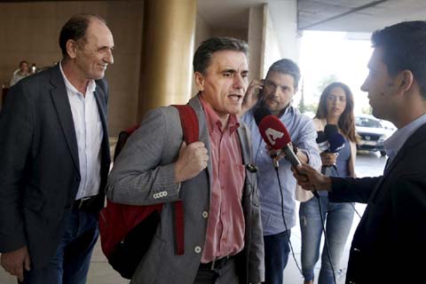 Greek Finance Minister Euclid Tsakalotos (C) speaks to the media while Economy Minister George Stathakis (L) looks on as they leave a hotel following an overnight meeting with representatives of the International Monetary Fund, the European Commission, th