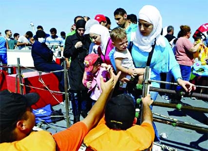 Members of the Turkish coast guards help a Syrian migrant family to disembark on the shore in Cesme, near the Aegean port city of Izmir, Turkey, August 11. Photo: Agency