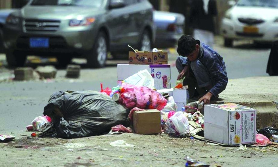 A poor boy searching food from a dustbin in Yemenâ€™s capital Saana .