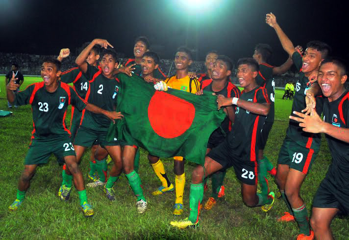 Players of Bangladesh Under-16 Football team celebrating with the national flag after beating India Under-16 Football team by 2-1 goals in their match of the SAFF Under-16 Championship at Sylhet District Stadium on Thursday.