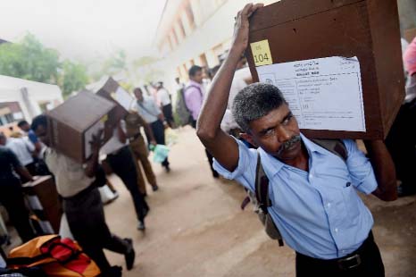 An election commission worker carries a ballot box on the eve of Sri Lanka's parliamentary elections, in Colombo on Sunday.