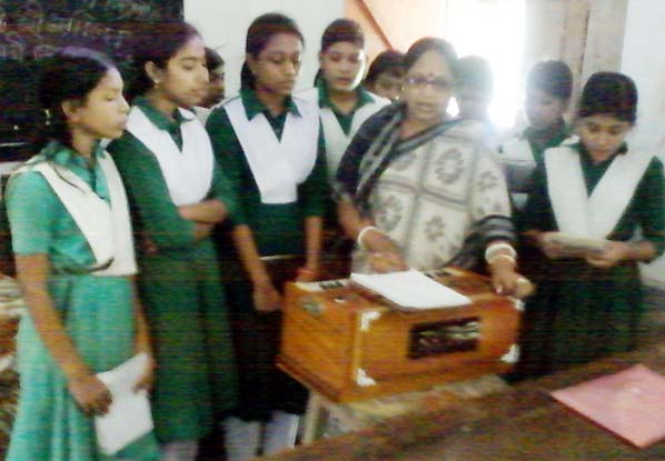 Sangita Chowdhury teacher of Sree Orbindh Girls' High School rendering songs with students of the school at a cultural function at the school premises on the occasion of the National Mourning Day and 40th martyrdom anniversary of Father of the Natio