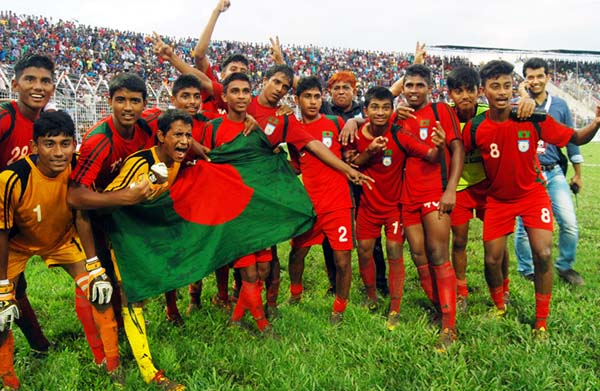 Members of Bangladesh Under-16 Football team celebrating with the national flag after beating Afghanistan Under-16 Football team by a solitary goal in the semi-final match of the SAFF Under-16 Championship at the Sylhet District Stadium on Sunday.