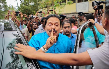 Parliamentary candidate Mahinda Rajapaksa gestures outside a polling station after casting his vote in Medamulana village, southern Sri Lanka.