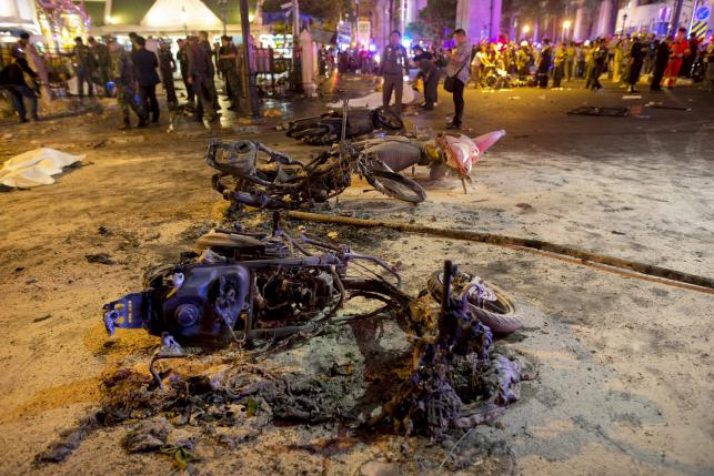 Wreckage of motorcycles are seen as security forces and emergency workers gather at the scene of a blast in central Bangkok August 17, 2015. A bomb on a motorcycle exploded on Monday just outside a Hindu shrine in the centre of the Thai capital, killing
