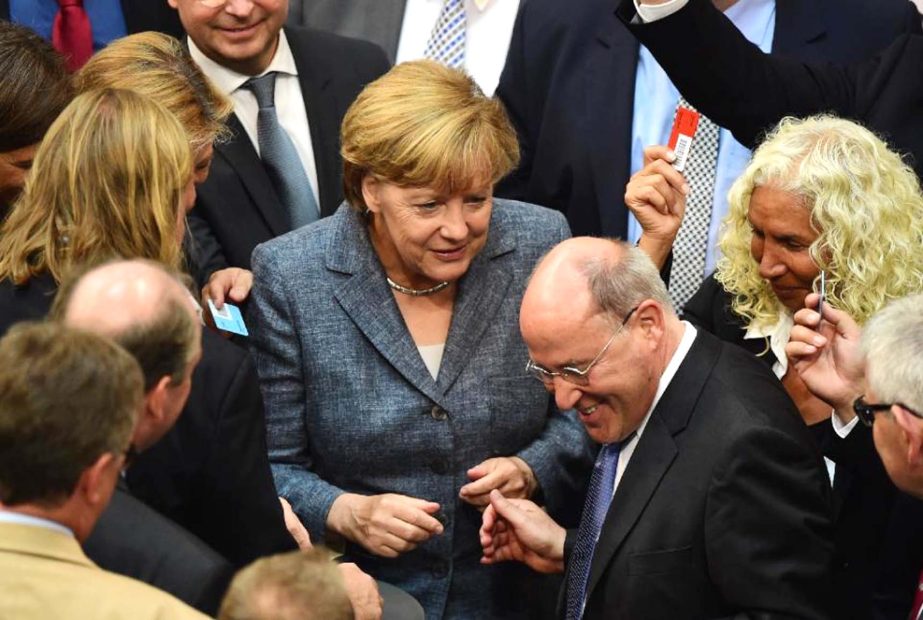 German Chancellor Angela Merkel (C) talks with MPs during a vote on a third bailout for debt-mired Greece at the Bundestag in Berlin on Wednesday.