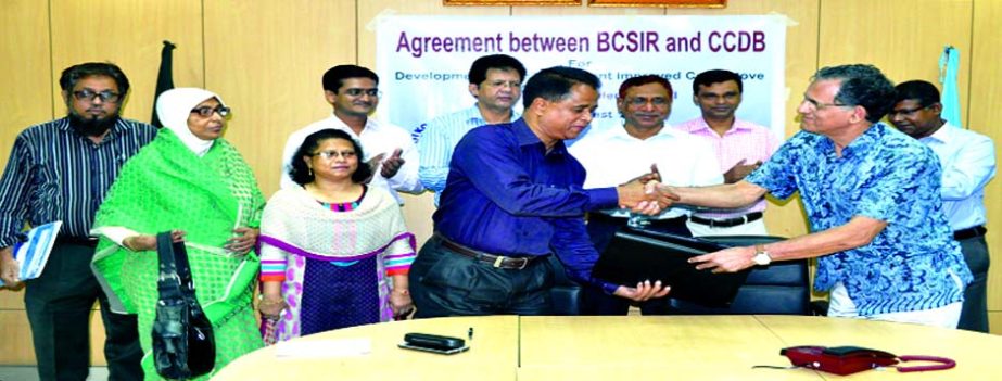 Md Khalilur Rahman, Secretary of BCSIR and Joyanta Adhkari, Executive Director of CCDB, sign an agreement for development of 'Highly Efficient Improved Cook Stove' on Wednesday. Md Nazrul Islam, Chairman of BCSIR, handing over the deeds, Member (Fin) Mo