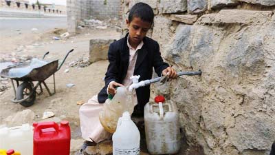 A Yemeni boy callecting water from a road side tape.