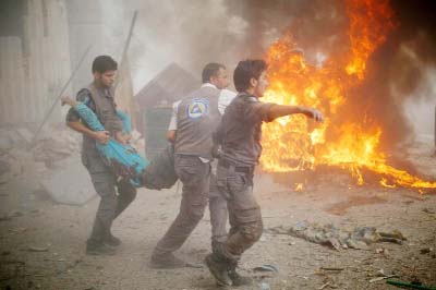 Syrian emergency personnel carry a wounded man following air strikes by Syrian government forces on a marketplace in the rebel-held area of Douma, east of the capital Damascus.
