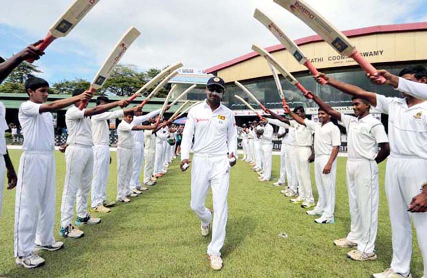 Sri Lankan cricketer Kumar Sangakkara (center) is greeted with an arch of bats as he enters the field for the last match of his test cricket career, the second Test cricket match between Sri Lanka and India in Colombo, Sri Lanka on Thursday.