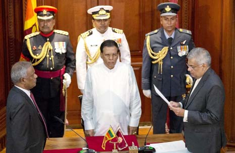 Ranil Wickremesinghe, right, takes oath as Sri Lanka's prime minister in front Sri Lanka's president Maithripala Sirisena, center, in Colombo, Sri Lanka on Friday.