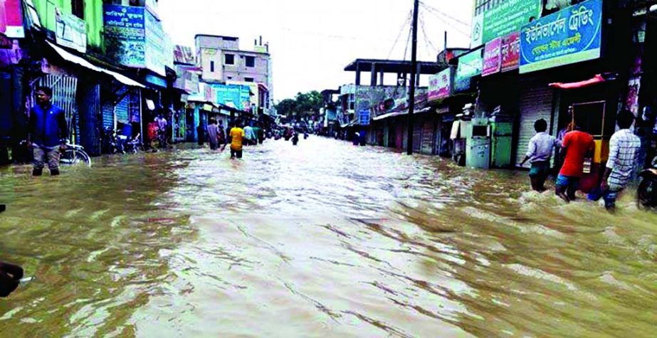 The flash flood inundates vast areas of Fenis, Fulgazi and Parashuram upazilas. Roads and local communications also went under floodwater. The picture was taken from the submerged road at Fulgazi Bazar on Friday.