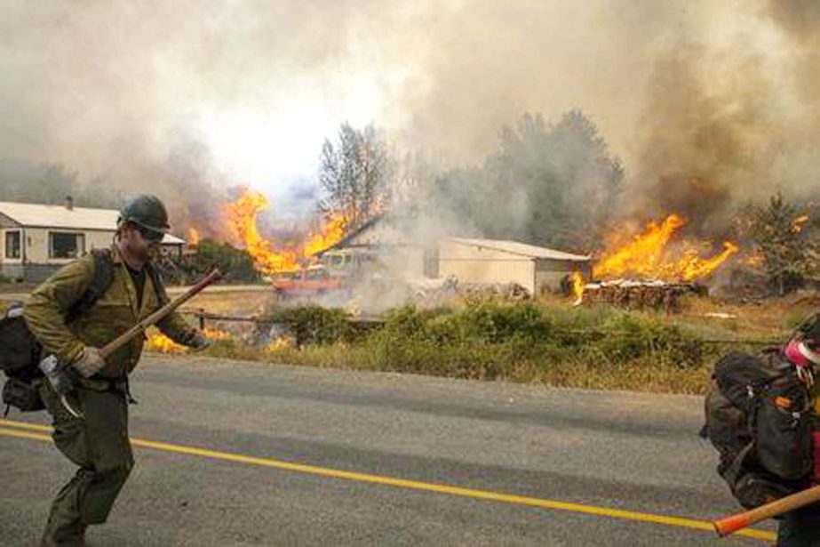 Firefighters flee as the Twisp River fire advances unexpectedly near Twisp, Washington on Friday