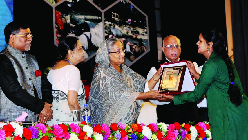 Prime Minister Sheikh Hasina handing over Best Community Clinic Award-2014 among the winners for their contribution in health services at a ceremony organized at Osmani Memorial Auditorium in the city on Saturday. BSS photo