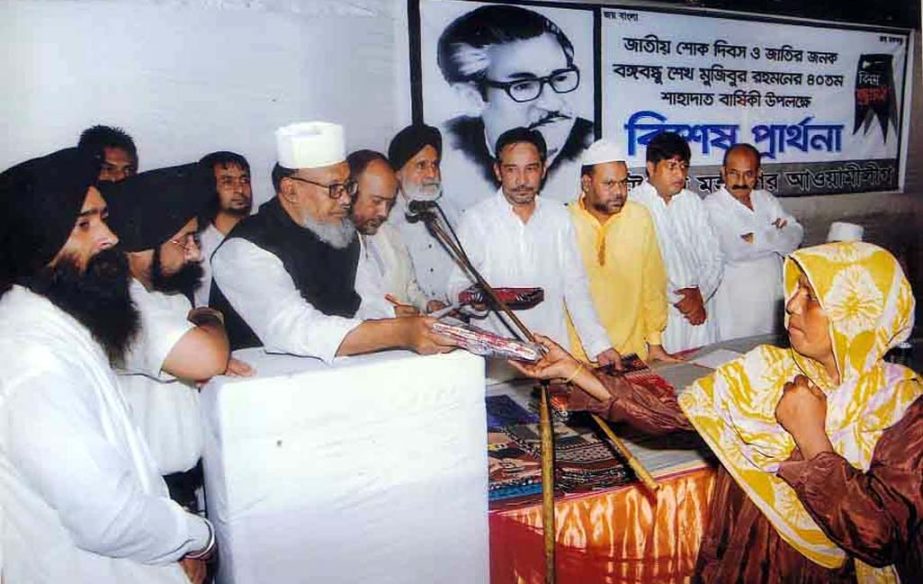 A B M Mohiuddin Chowdhury distributing clothes at a programme marking the National Mourning Day recently.