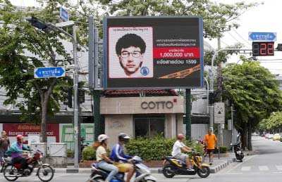 People ride their motorcycles past a digital billboard showing a sketch of the main suspect in Monday's attack on Erawan shrine, in Bangkok, Thailand, on Sunday.