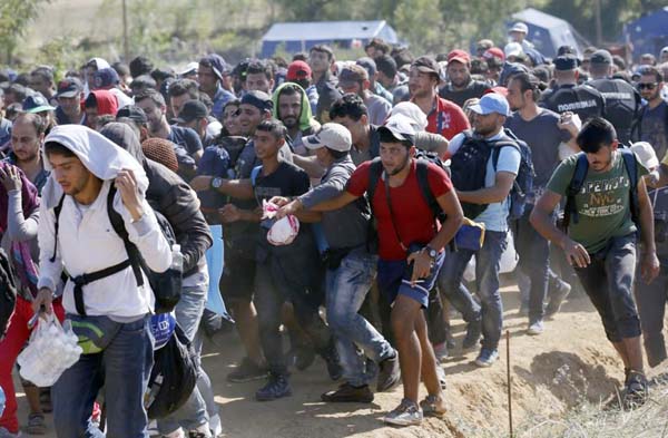 Migrants rush into Serbia over the border with Macedonia near the village of Miratovac, Serbia on Monday.