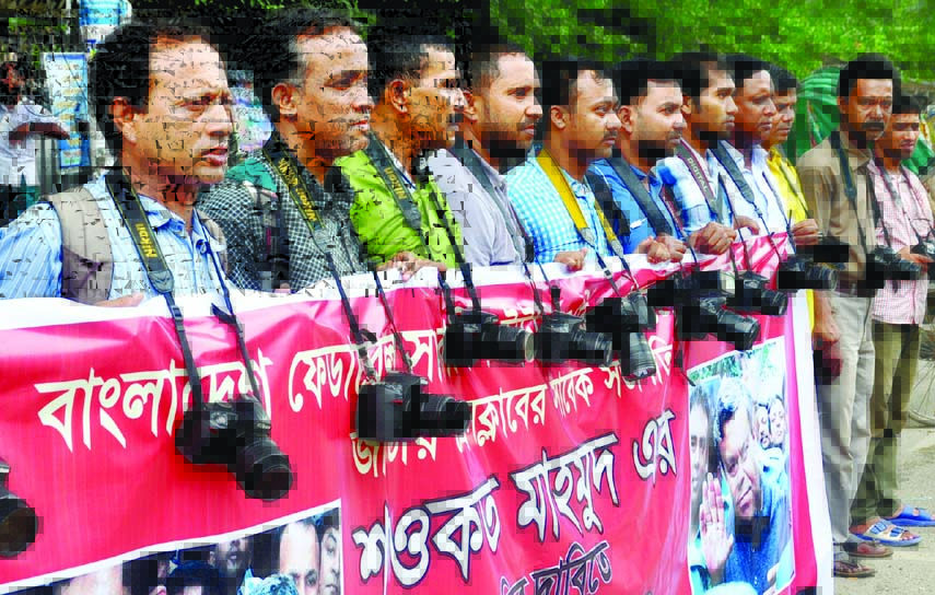 A section of photojournalists formed a human chain in front of the Jatiya Press Club on Tuesday demanding release of Shawkat Mahmud, President of a faction of BFUJ.