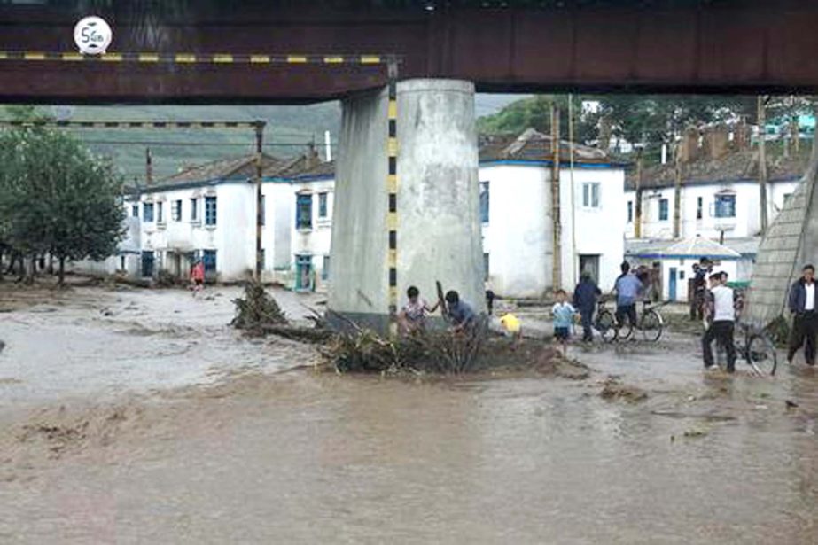 Residents attempt to clear flood debris from under a bridge in the city of Rajin in North Korea.
